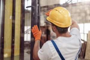 Male,Builder,Repairing,Door,In,Building,Under,Construction